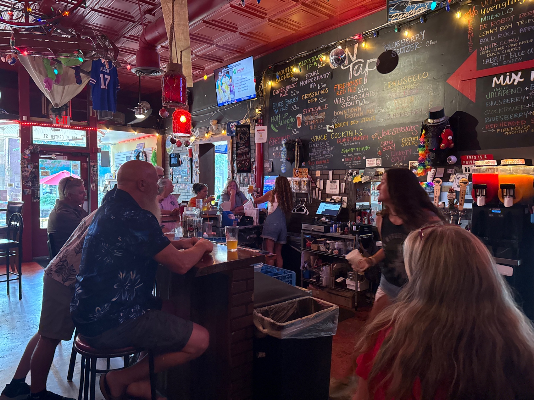 Red Buffalo Brewing taproom bar with chalkboard tap list and guests
